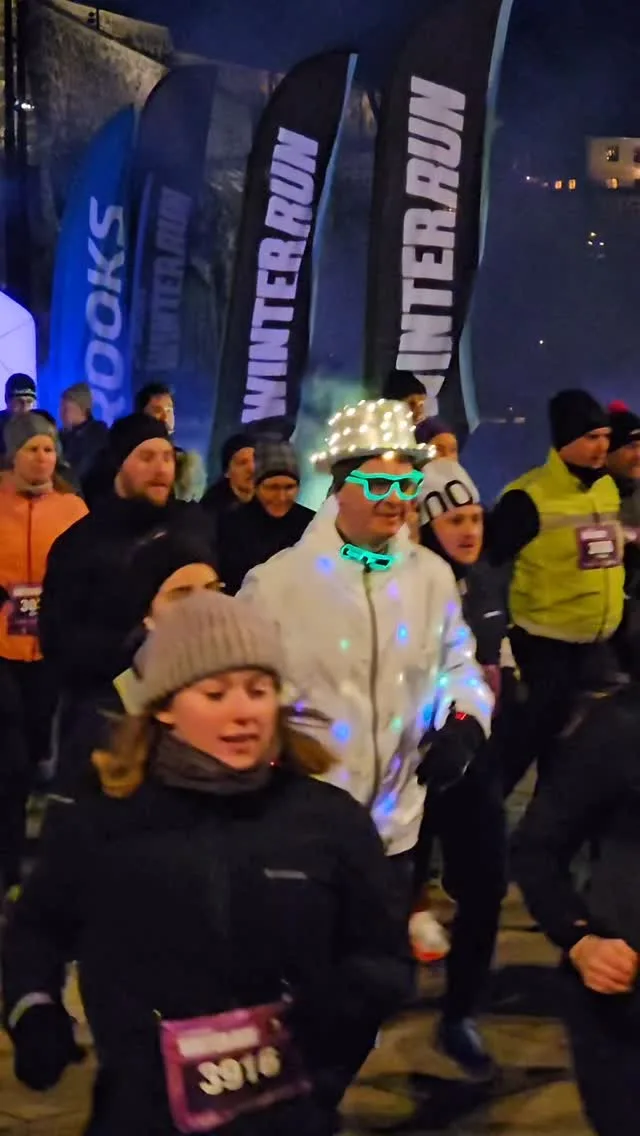 Deltakere under den opplyste startportalen til WinterRun 2026 i Oslo